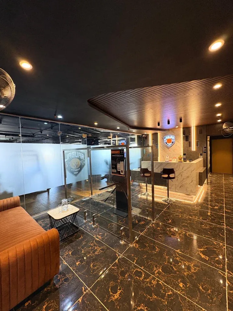Reception lounge with an orange sofa, glass partitions and the reception desk beyond